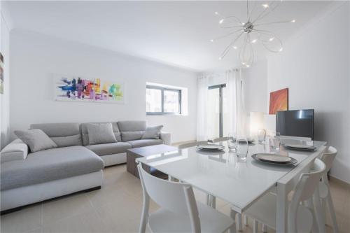ein weißes Wohnzimmer mit einem Tisch und einem Sofa in der Unterkunft LUX Seaview & Pool-Hosted by Sweetstay in Mellieħa