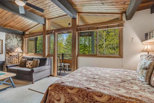 a bedroom with a bed and a couch and windows at Laurelwood Condominiums 208 in Snowmass Village