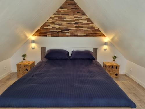 a bedroom with a large bed with purple pillows at La vie Est Belle Vlissingen in Vlissingen