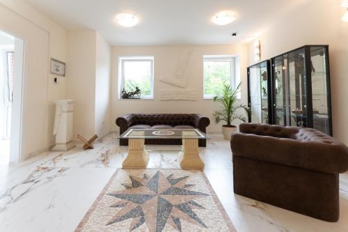 a living room with two couches and a coffee table at Hotel & Restaurant Sparta in Oldenburg