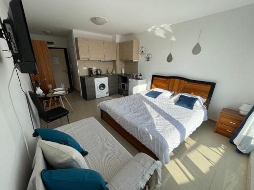 a bedroom with a bed and a tv and a kitchen at Admiral Plaza in Sunny Beach