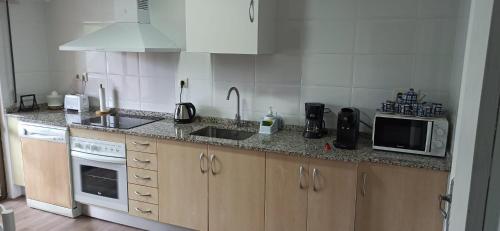 a kitchen with a sink and a microwave at El Mirador de la Villa in Puebla de Sanabria