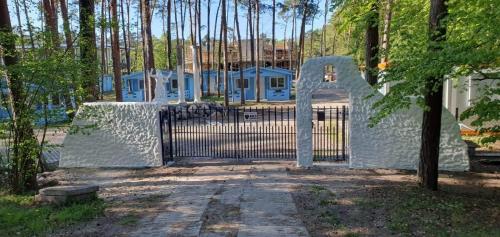 a gate to a driveway with a house and trees at DOMKI ZEUS in Stegna