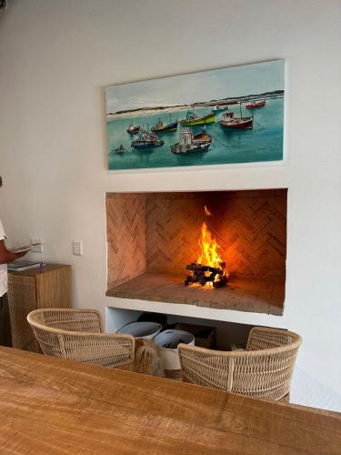 a fire in a fireplace in a room with chairs at Seagulls Nest in Struisbaai