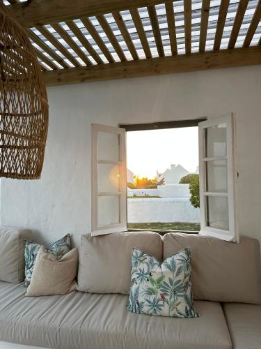 a couch sitting in a room with two windows at Seagulls Nest in Struisbaai