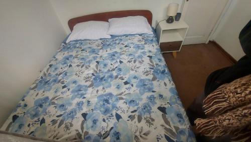 Una cama con una manta azul y blanca. en Dormitorio con baño y acceso independiente, en Santiago