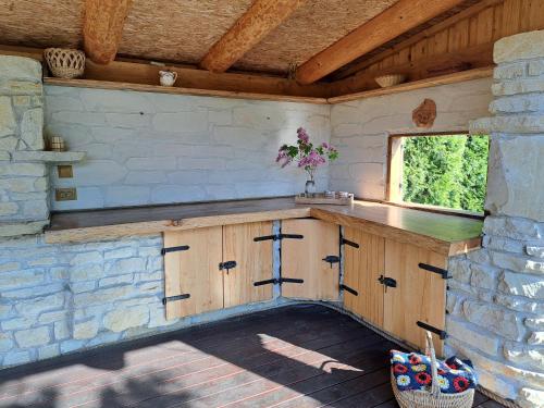 a kitchen with wooden cabinets and a window at Cosy guesthouse with sauna and outdoor kitchen in Kuressaare