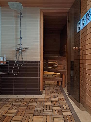 uma casa de banho com um chuveiro e uma porta de vidro em Cosy guesthouse with sauna and outdoor kitchen em Kuressaare