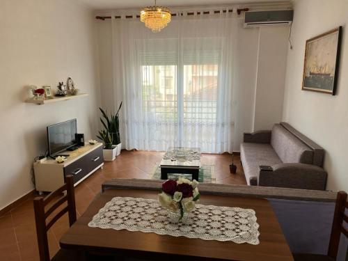 un soggiorno con un tavolo e un divano di Amal Vlora Apartament a Vlorë