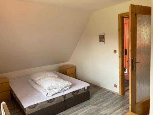 a small bedroom with a bed with white sheets at Chata Severka in Dolný Kubín