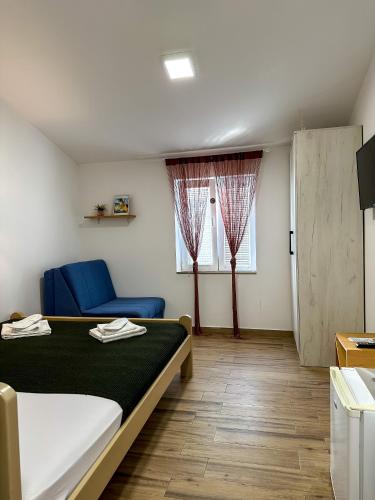 a bedroom with a bed and a blue couch and window at Serenita Stone House in Becici