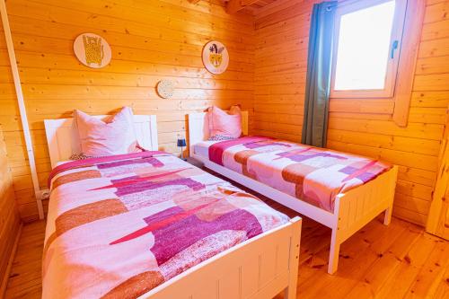 sypialnia z 2 łóżkami w drewnianym domku w obiekcie Chalet Gayar w mieście La Plaine des Cafres