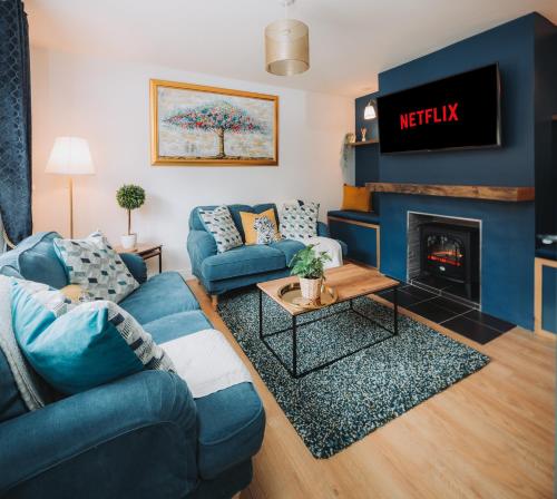 a living room with a blue couch and a fireplace at Cosy Hot Tub Getaway Bungalow in Armagh