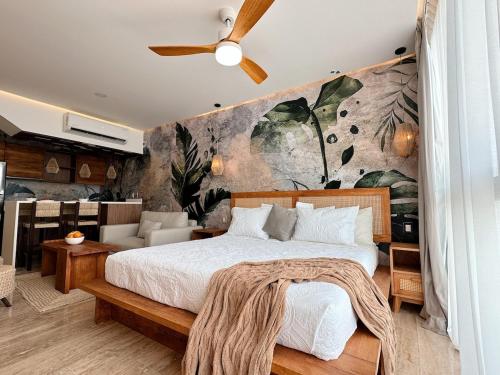 um quarto com uma cama e uma parede com plantas em Amour 307 em Tulum