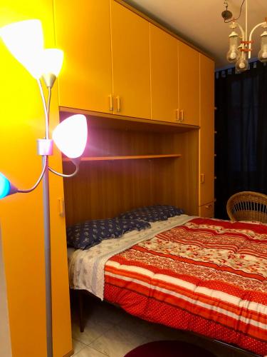 um quarto com uma cama, um candeeiro e armários em L’Albero Colorato em Candelo