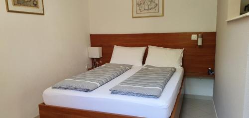 a bed with two pillows on it in a room at Apartments Ginkgo in Banjole