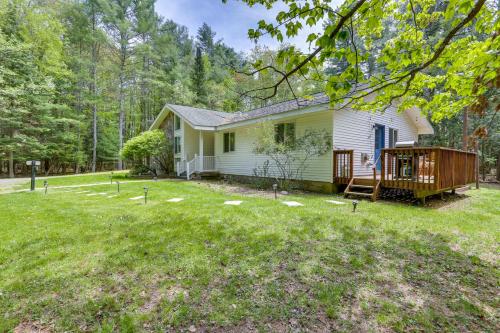 a small white house with a deck in the yard at Charming Swan Lake Apartment with Deck! in Swan Lake