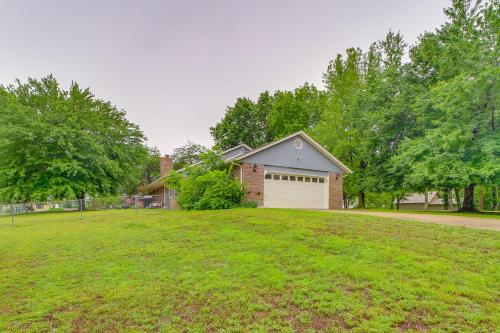a house with a garage in a grassy yard at Family, Friends and Fishing Home Near Grand Lake in Grove