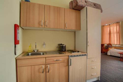a kitchen with wooden cabinets and a sink at Ebsens Hotel in Maribo