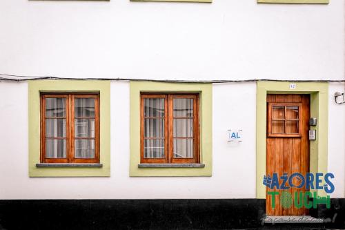 a white building with three windows and a door at Atlântida Dream in Angra do Heroísmo