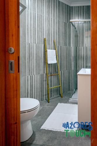 a bathroom with a toilet and two chairs in a shower at Atlântida Dream in Angra do Heroísmo