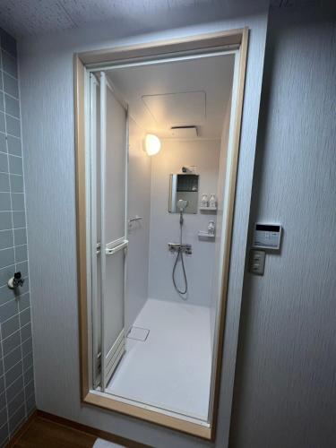 a bathroom with a shower with a glass door at Fukuro no Oyado Shinkan - Vacation STAY 59589v in Fuefuki