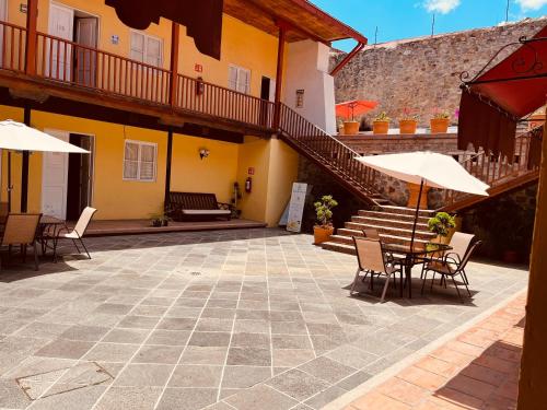 a patio with chairs and umbrellas in front of a building at Hotel Real Del Monte in Mineral del Monte