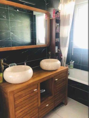 - une salle de bains avec deux lavabos au-dessus d'un comptoir en bois dans l'établissement Maison 3 chambres au calme, à Pluvigner