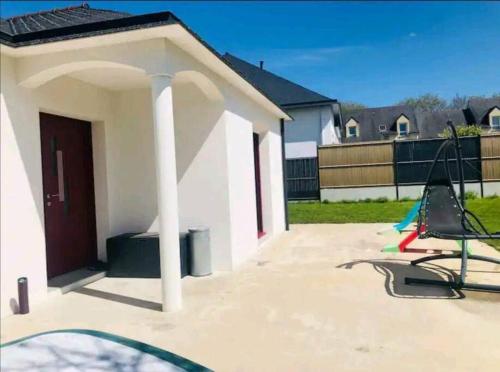une petite maison blanche avec une table et des chaises dans une cour dans l'établissement Maison 3 chambres au calme, à Pluvigner