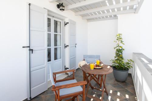 a balcony with a table and chairs and a door at Sea Lilies Suites in Plaka