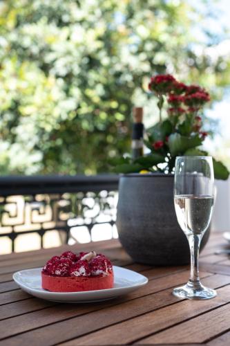 a plate of food and a glass of wine on a table at Sea Lilies Suites in Plaka