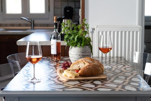 a table with two glasses of wine and a plate of bread at Sea Lilies Suites in Plaka