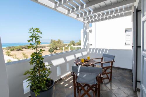 a patio with a table and chairs on a balcony at Sea Lilies Suites in Plaka