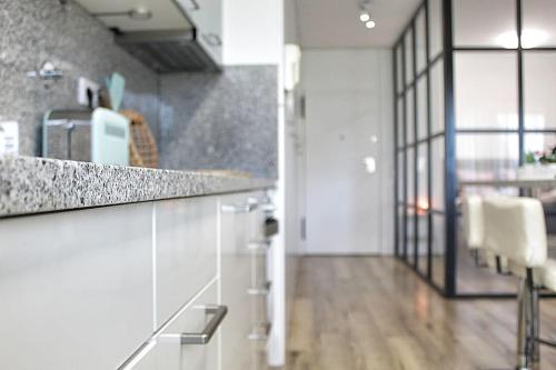 une cuisine avec un comptoir et un couloir avec une table dans l'établissement Arrábida Luxury Studio, à Vila Nova de Gaia