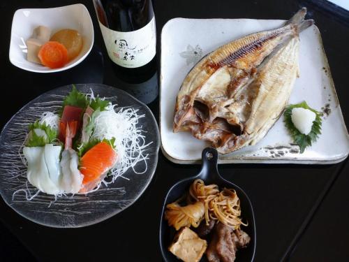 a table topped with plates of food with a fish at Abashirikai no Taiyo - Vacation STAY 14558 in Abashiri