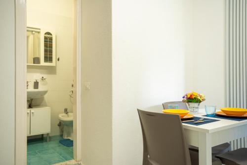 ein Esszimmer mit einem Tisch und Stühlen sowie ein Badezimmer in der Unterkunft La Baia Blu - Ischia in Ischia