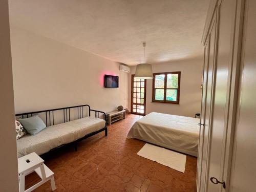 a bedroom with two beds and a tv on the wall at Villa Rosa in Chia