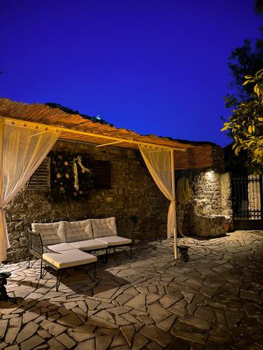 a couch under a tent on a stone patio at night at Serenita Stone House in Becici