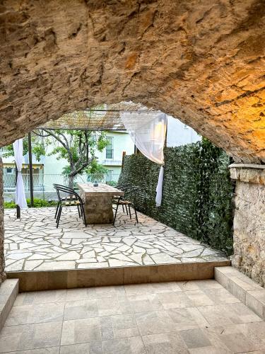 a stone patio with a table and chairs under a stone wall at Serenita Stone House in Becici