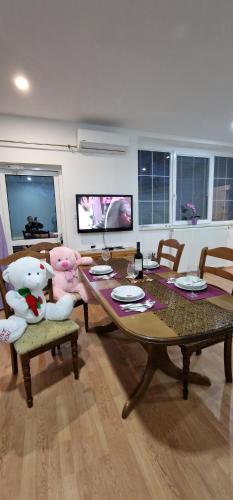 a dining room with a table and chairs with stuffed animals at APARTMAN MURKO P-4 in Ljubljana