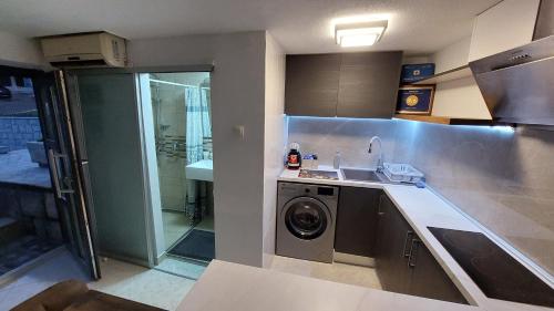 a kitchen with a sink and a washing machine at Opatija Centar in Opatija