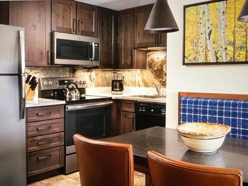 una cocina con armarios de madera y una mesa con sillas. en Marriott's Mountain Valley Lodge, en Breckenridge