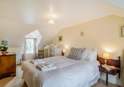 a bedroom with a bed with two towels on it at Vine Cottage in Walberswick
