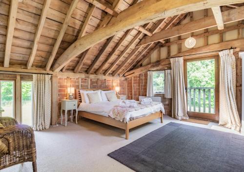 a bedroom with a bed in a room with wooden ceilings at Sewell Barn Sutton in Sutton