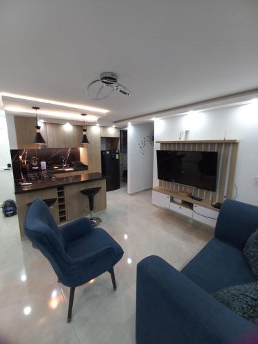 a living room with a tv and a couch and chairs at HERMOSO APARTAMENTO NUEVO AMOBLADO Conjunto Goya 503 Neiva in Neiva