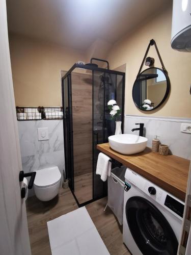 a bathroom with a sink and a washing machine at City Center Apartment Bravos in Makarska