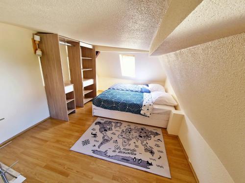 a small room with a bed and a rug at La casa de rosita, proche d'Europa-park et Rulantica in Benfeld
