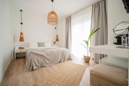 a white bedroom with a bed and a window at Sandal Alaçatı - Adult Only in Alacati