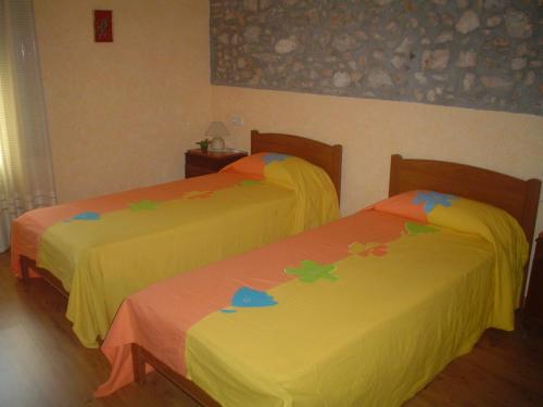 Dos camas con flores en una habitación en Can Bicicleta de Dalt, en Olesa de Bonesvalls