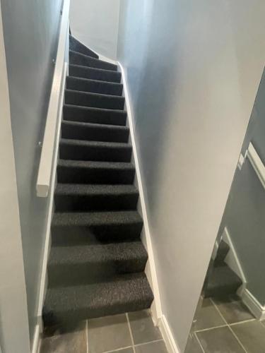 a stairway with black steps in a building at Riverside Lodge in Carlow